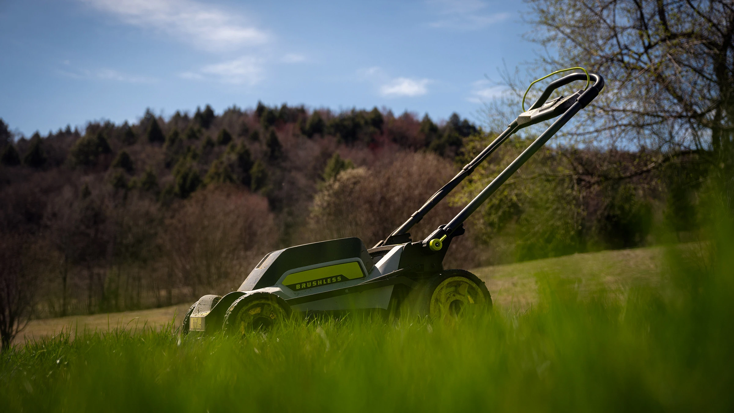 An electric lawn mower sitting in an open field.