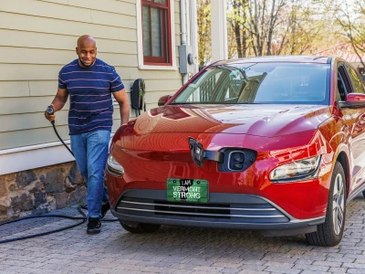 A man plugging in his electric vehicles at his home charger.